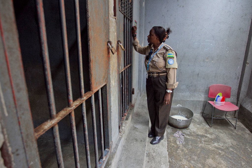 来自卢旺达的一名惩戒干事正在与太子港女子监狱的一名被拘留者进行